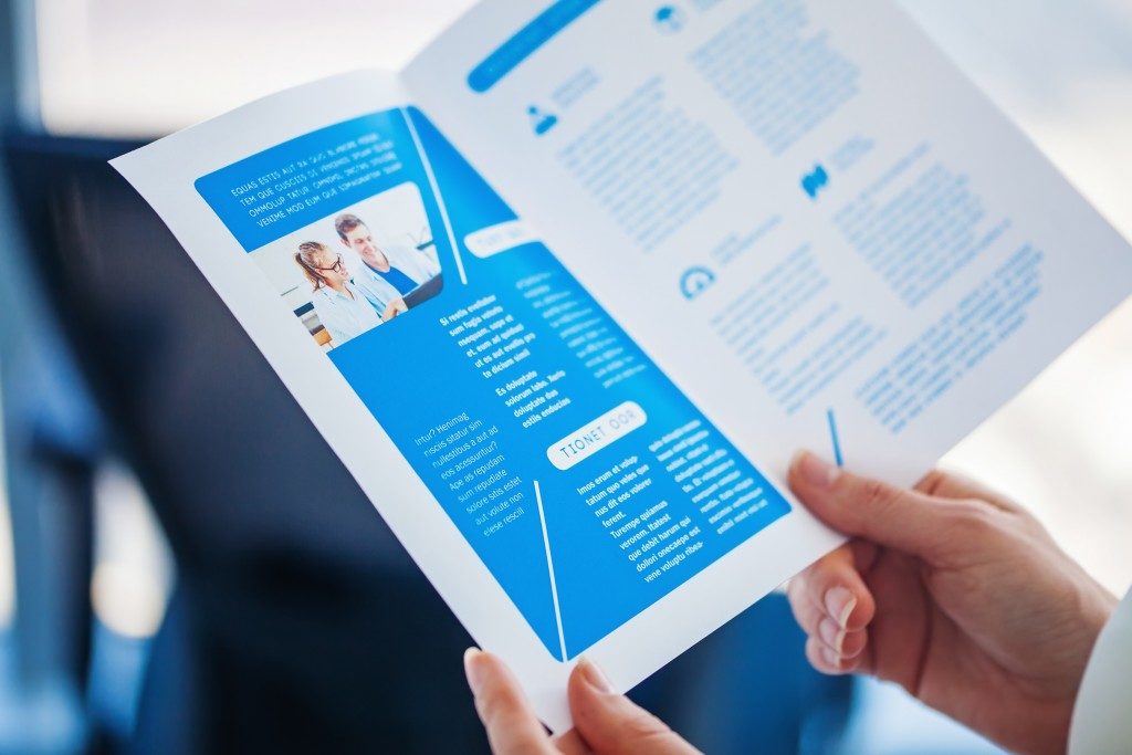 Hands holding a print of a business bi-fold brochure