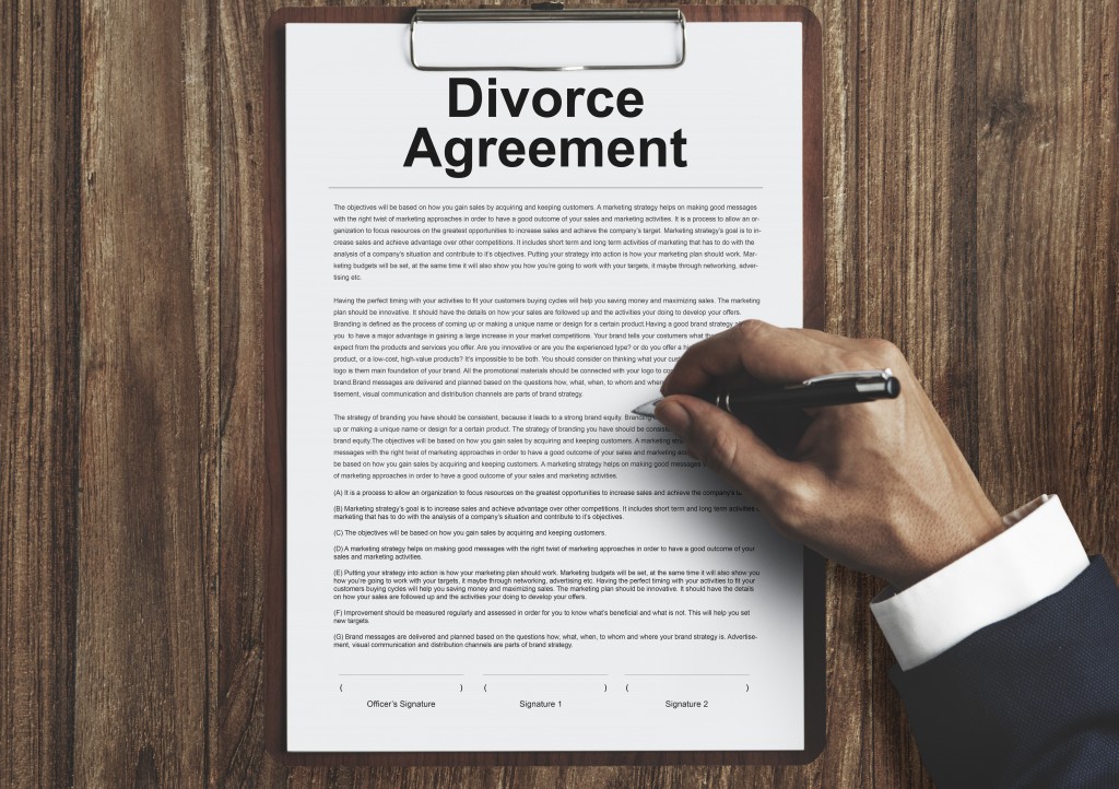 man signing on a divorce agreement document
