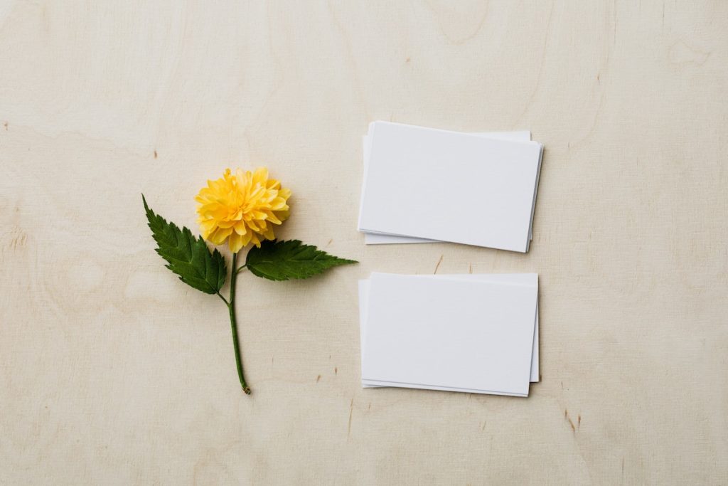 yellow flower next to white business cards