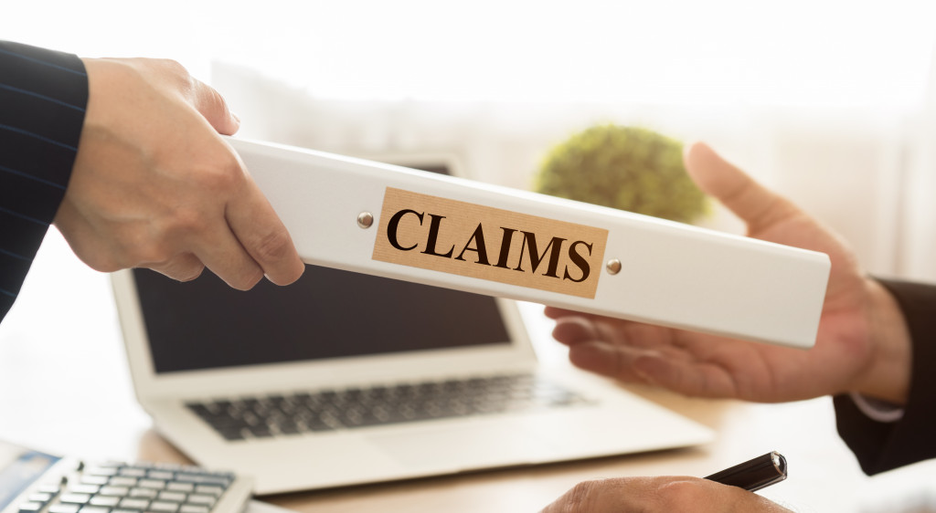 insurance agents handing a claims document to a lawyer