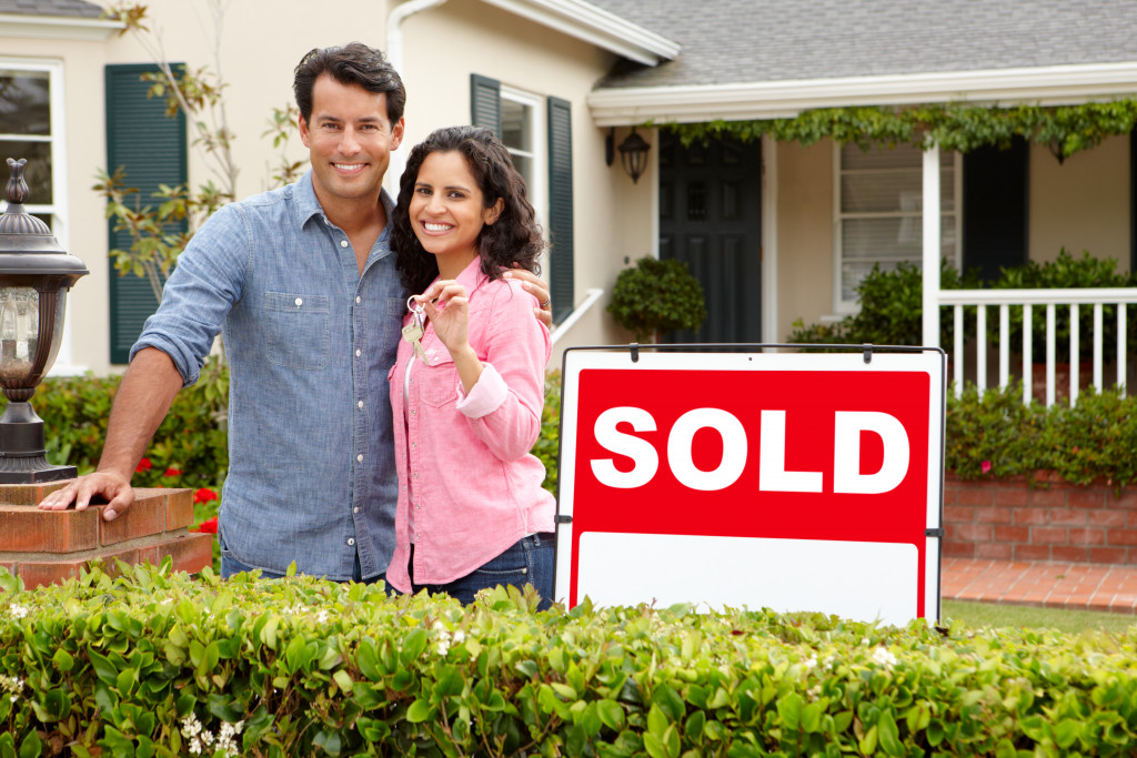 couple in front of a sold real estate