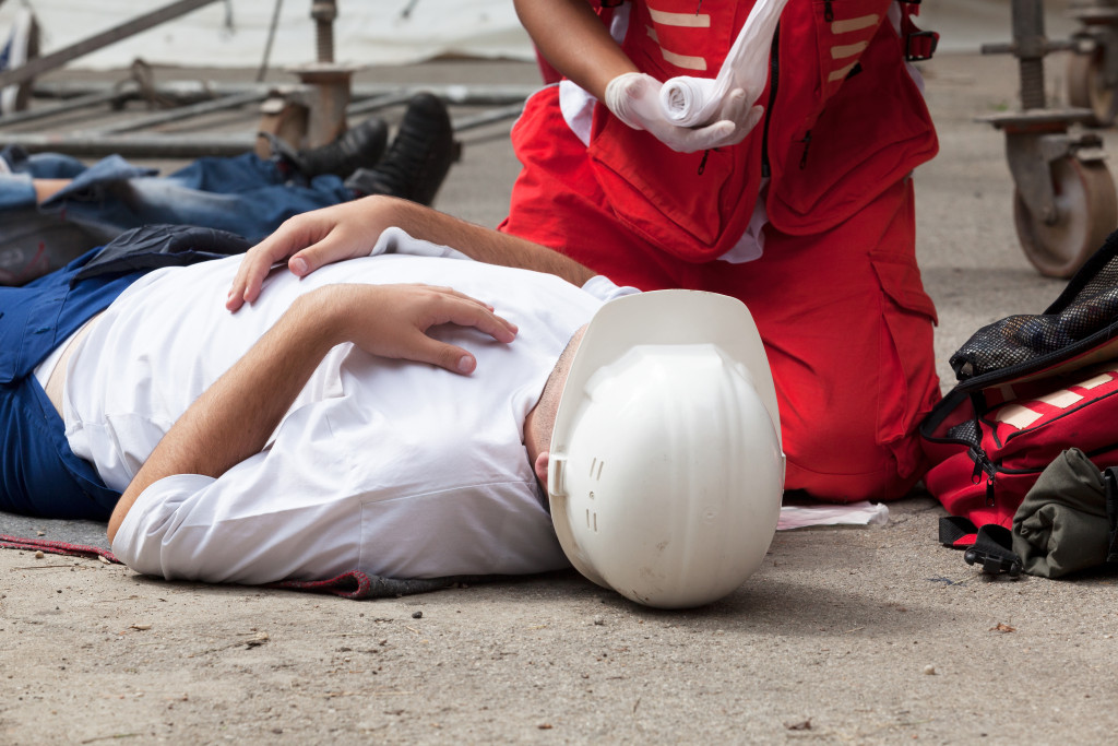 First aid technician helps a worker injured while at work.