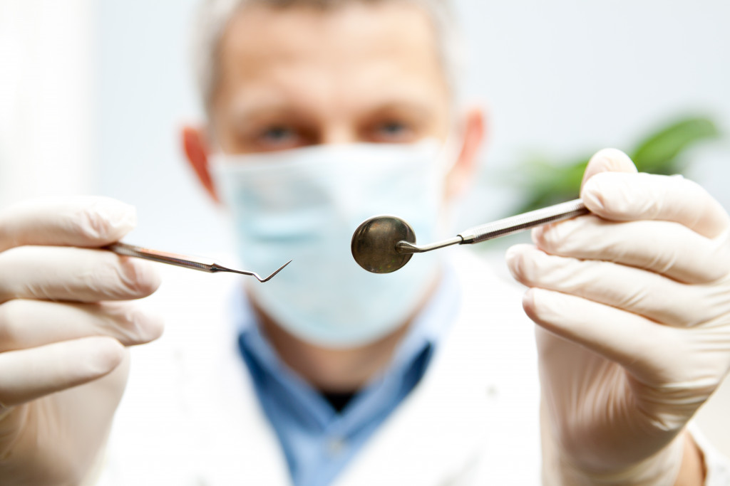 male dentist holding dental apparatus blurred background